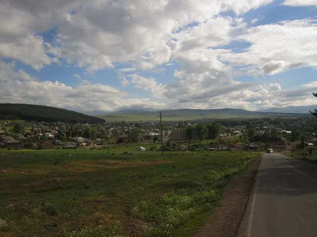 Osada Tsalka a okolní krajina pod zataženou oblohou.