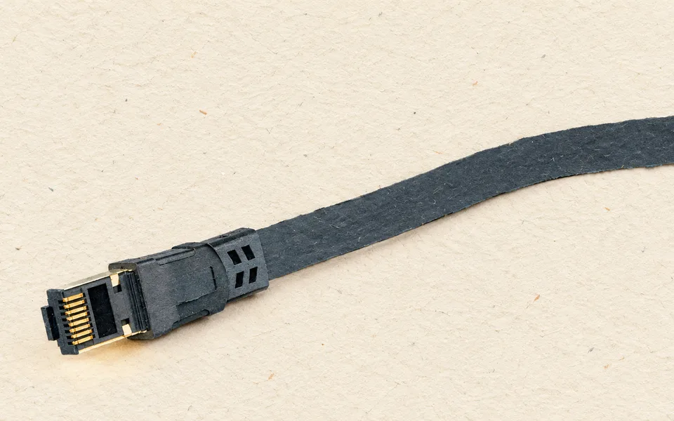 Ethernetový kabel s konektorem RJ45 na světlém povrchu.