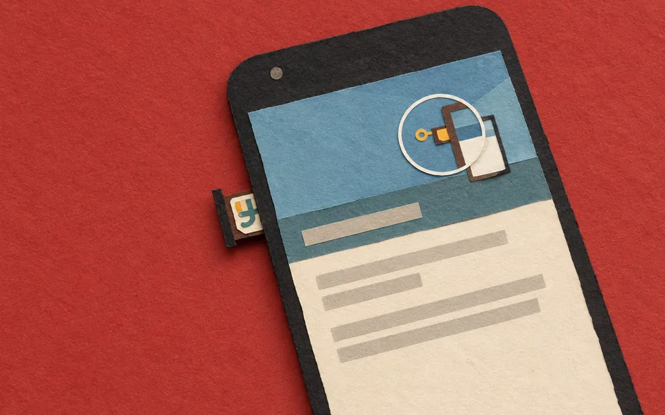 Telefon s Androidem, částečně vysunutou přihrádkou na SIM kartu a SIM kartou.